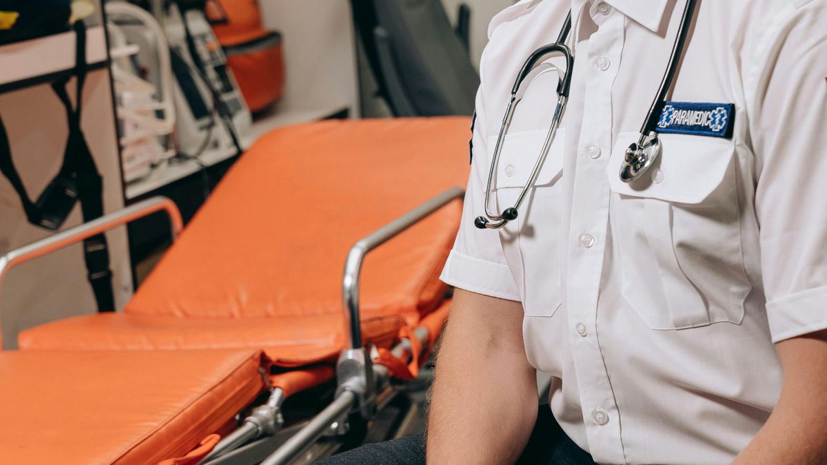 Paramedic with a stretcher inside an ambulance, where emergency assessment and treatment begin before hospital arrival