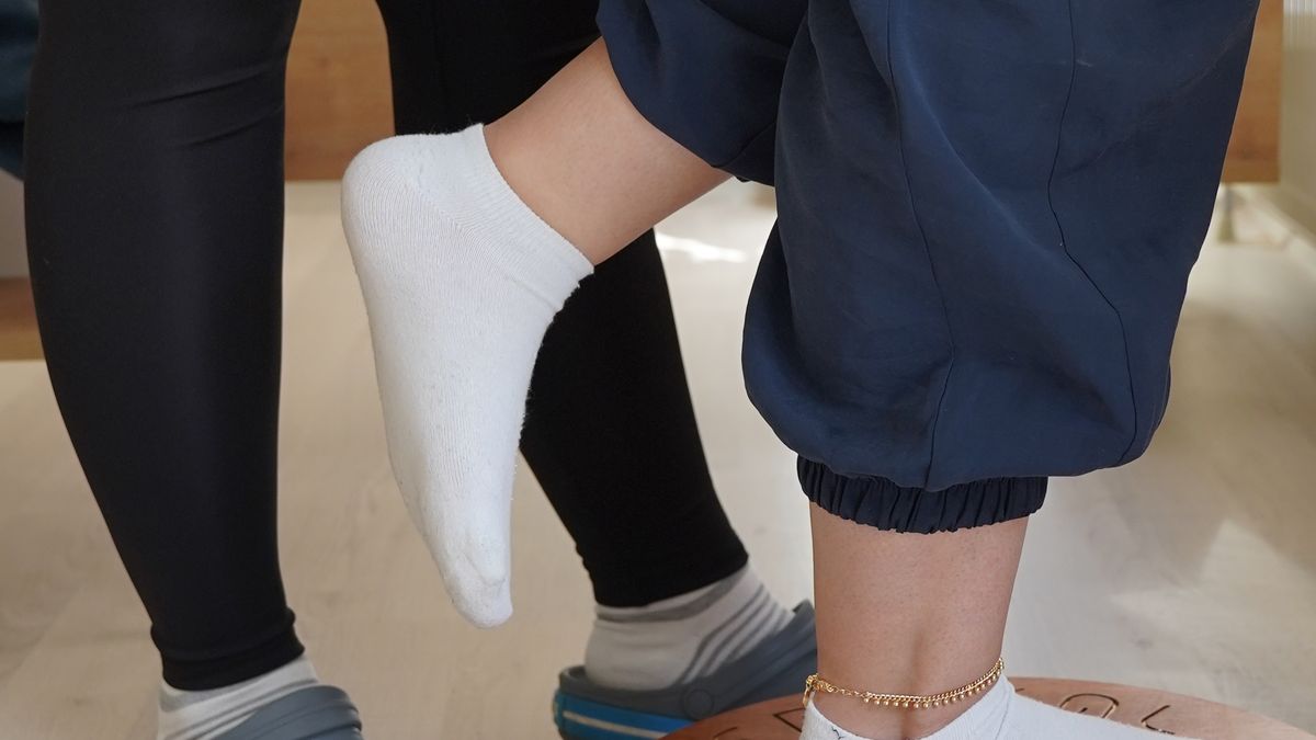 Patient doing balance board training as part of later-stage knee rehabilitation after joint replacement