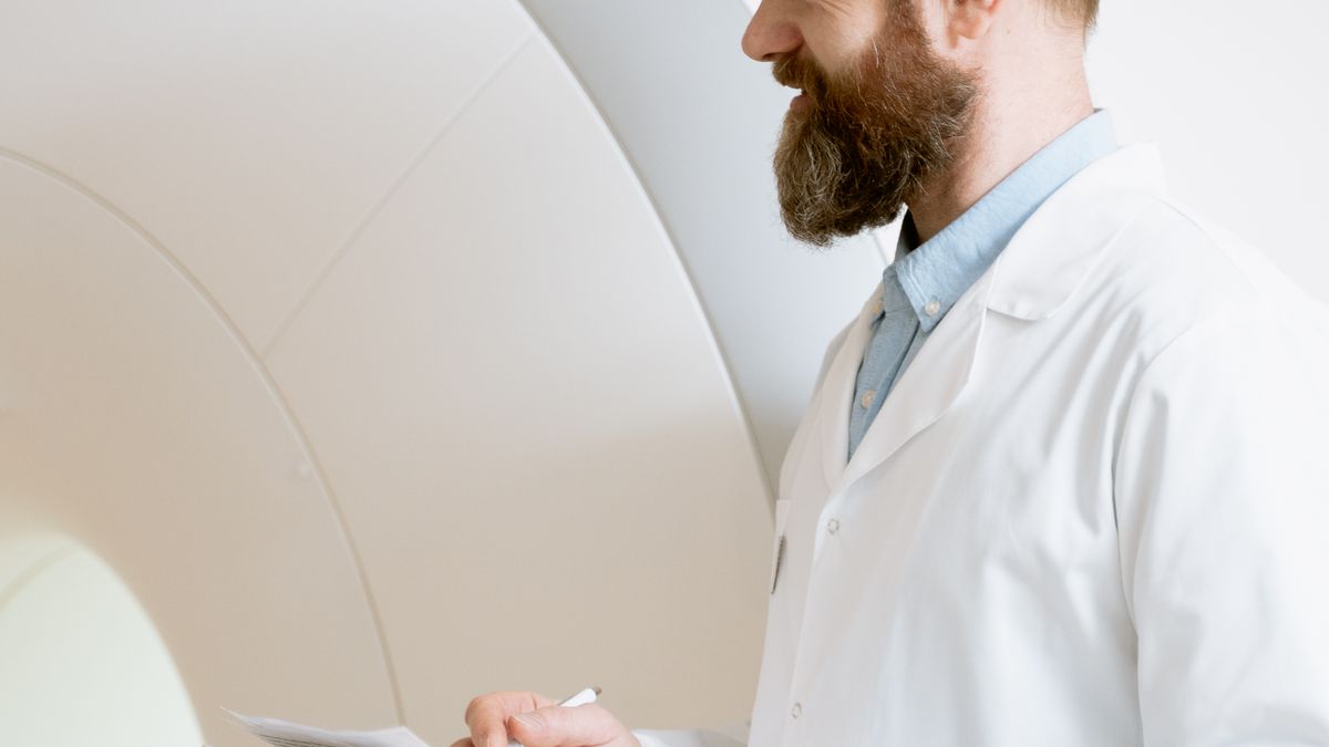 Doctor reviewing MRI scan images on screen to assess a patient's spine and nerve compression