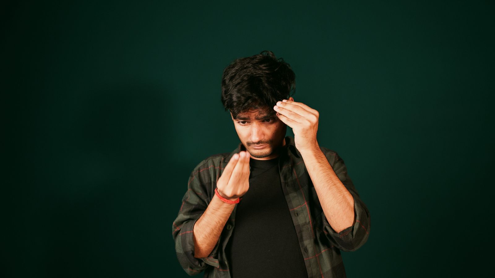 Young man checking his hair and hairline for early signs of thinning