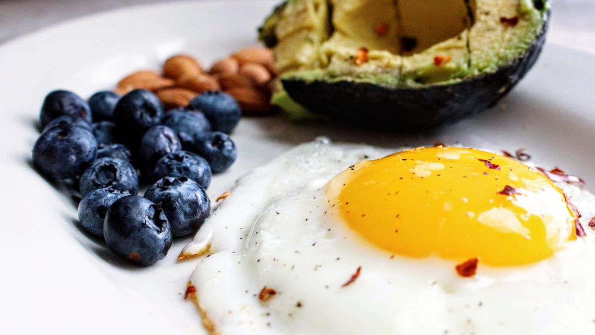 Protein-rich breakfast with egg, almonds, avocado and berries for healthy hair
